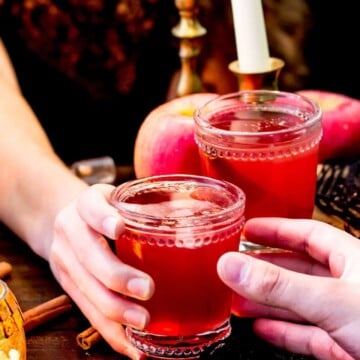 Glass of red liquid being handed off
