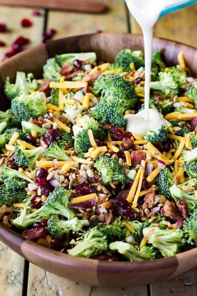 Easy delicious BROCCOLI SALAD with bacon is always a hit! Easy to make and packed with flavor! #summerfood #broccolisalad #salad #potluck How to make broccoli salad, combining ingredients and tossing with homemade dressing