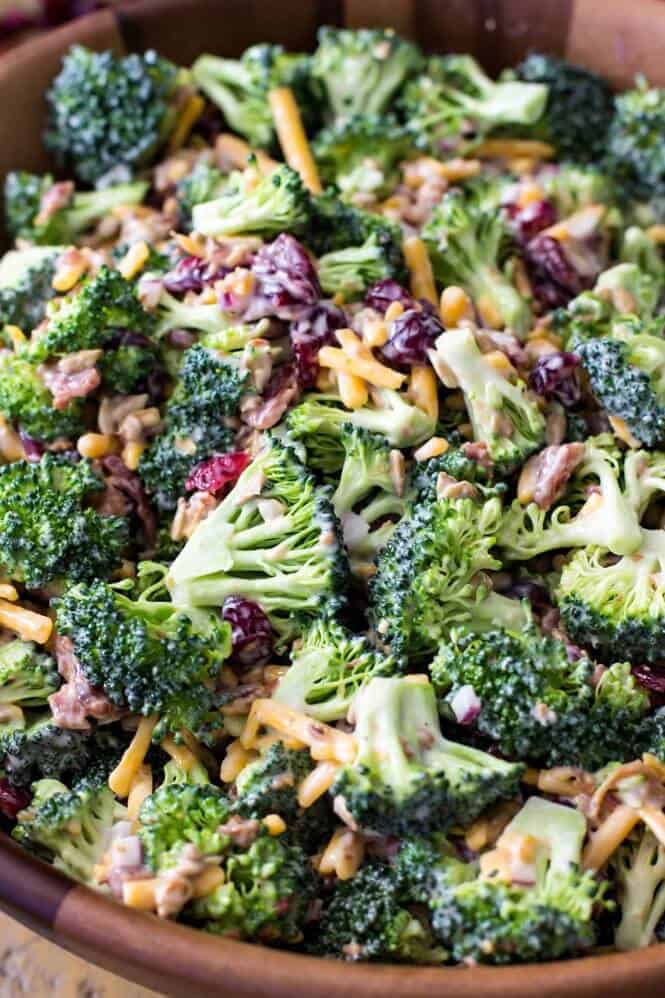 An easy and delicious BROCCOLI SALAD with bacon! This recipe is always a hit! Easy to make and packed with flavor! #summerfood #broccolisalad #salad #potluck Broccoli salad with bacon in a wooden serving bowl