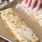 Biscotti dough shaped into rectangle on parchment paper lined baking sheet