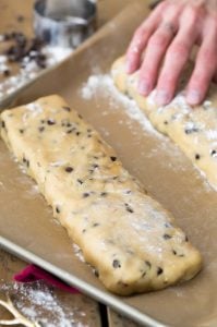 Biscotti dough shaped into rectangle on parchment paper lined baking sheet