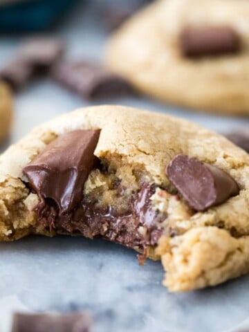 Chocolate chip cookie with bite missing showing melted gooey chocolate