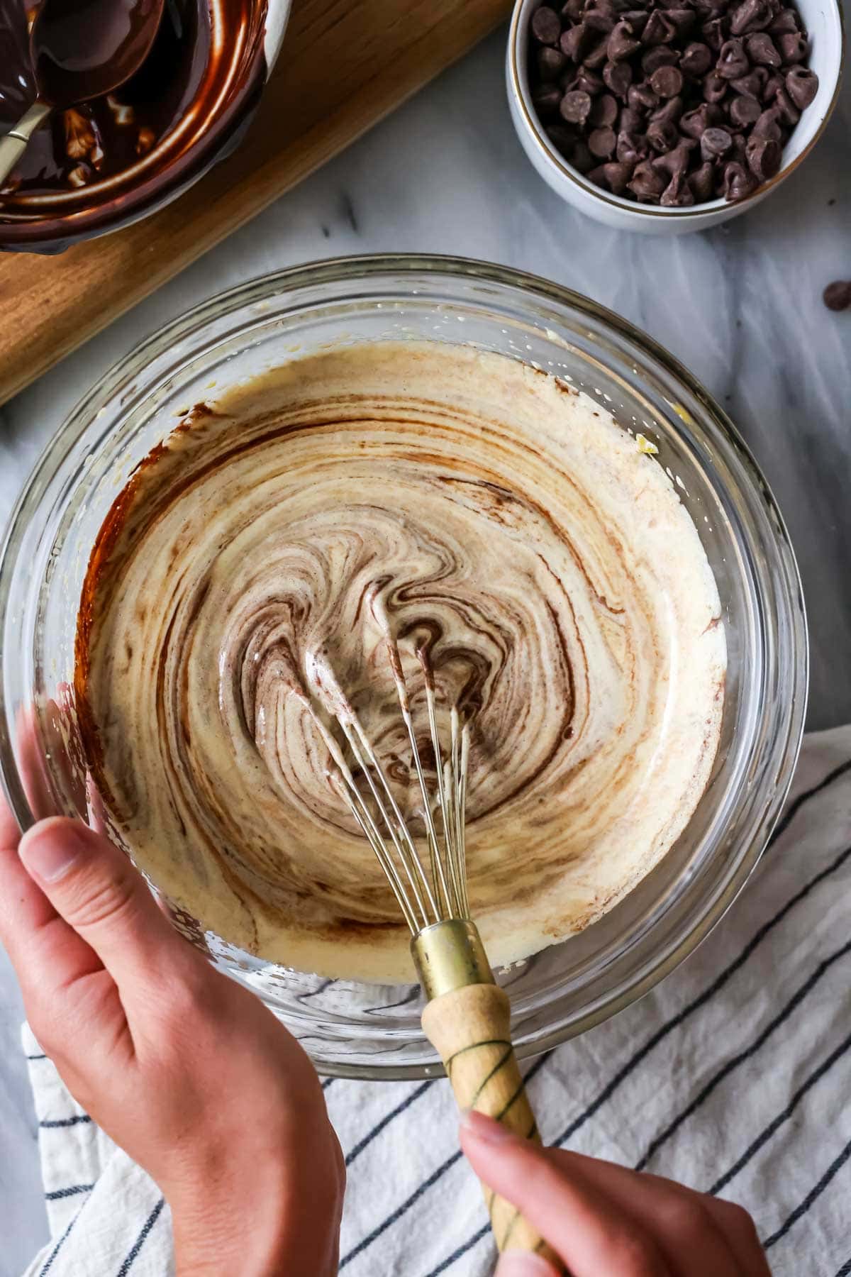 Whisking together egg/sugar mixture with melted chocolate.