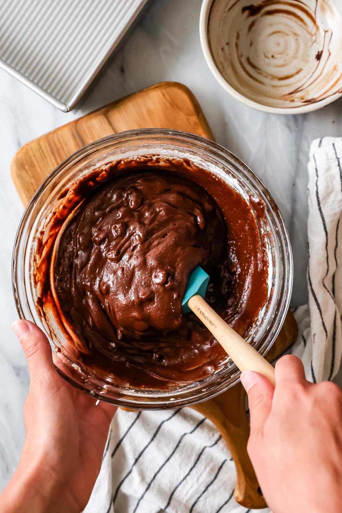 Glass bowl of brownie batter with chocolate chips.