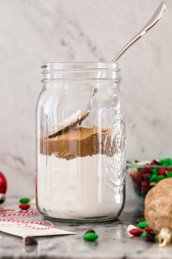 Making cookie mix in a jar: firmly packing dark brown sugar over flour mixture with a spoon