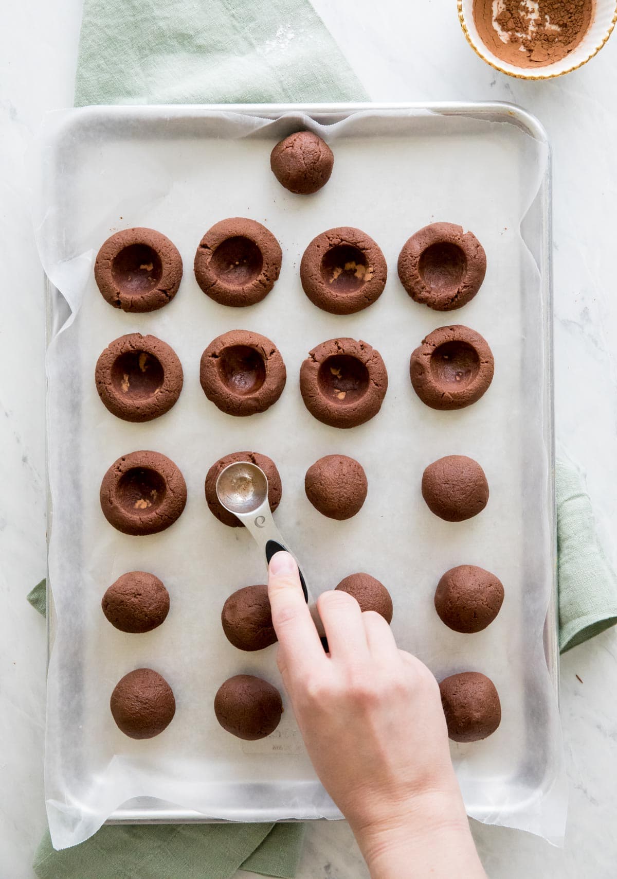 indenting chocolate cookies with a teaspoon