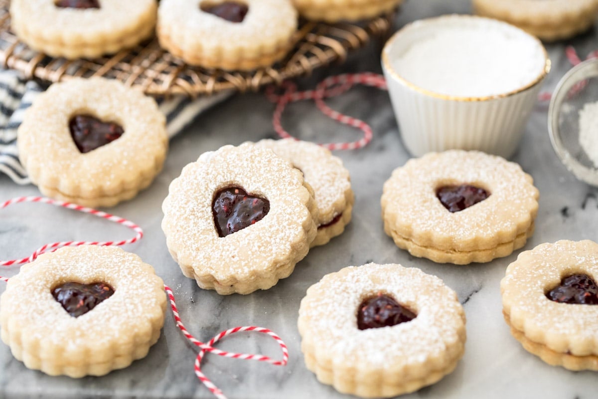 Linzer cookies on marble with red bakers twine