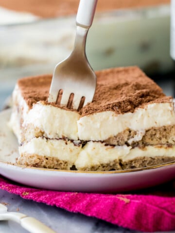 sticking a fork into a plate of tiramisu