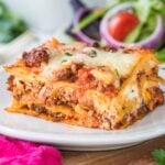 Closeup of finished lasagna showing the layers on a white plate