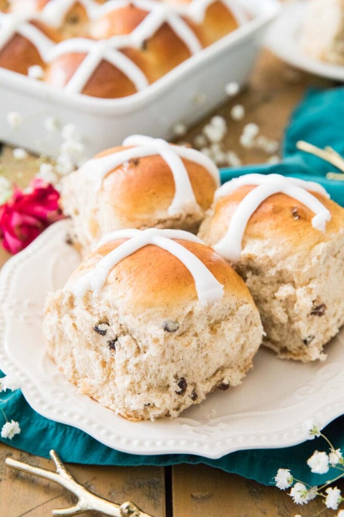 Three iced buns on a white plate.