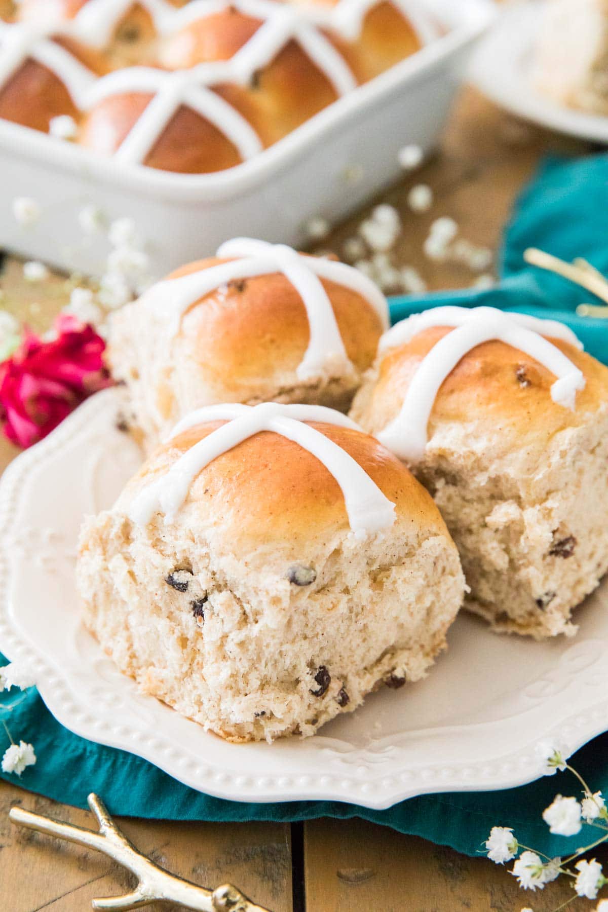 Three iced buns on a white plate.