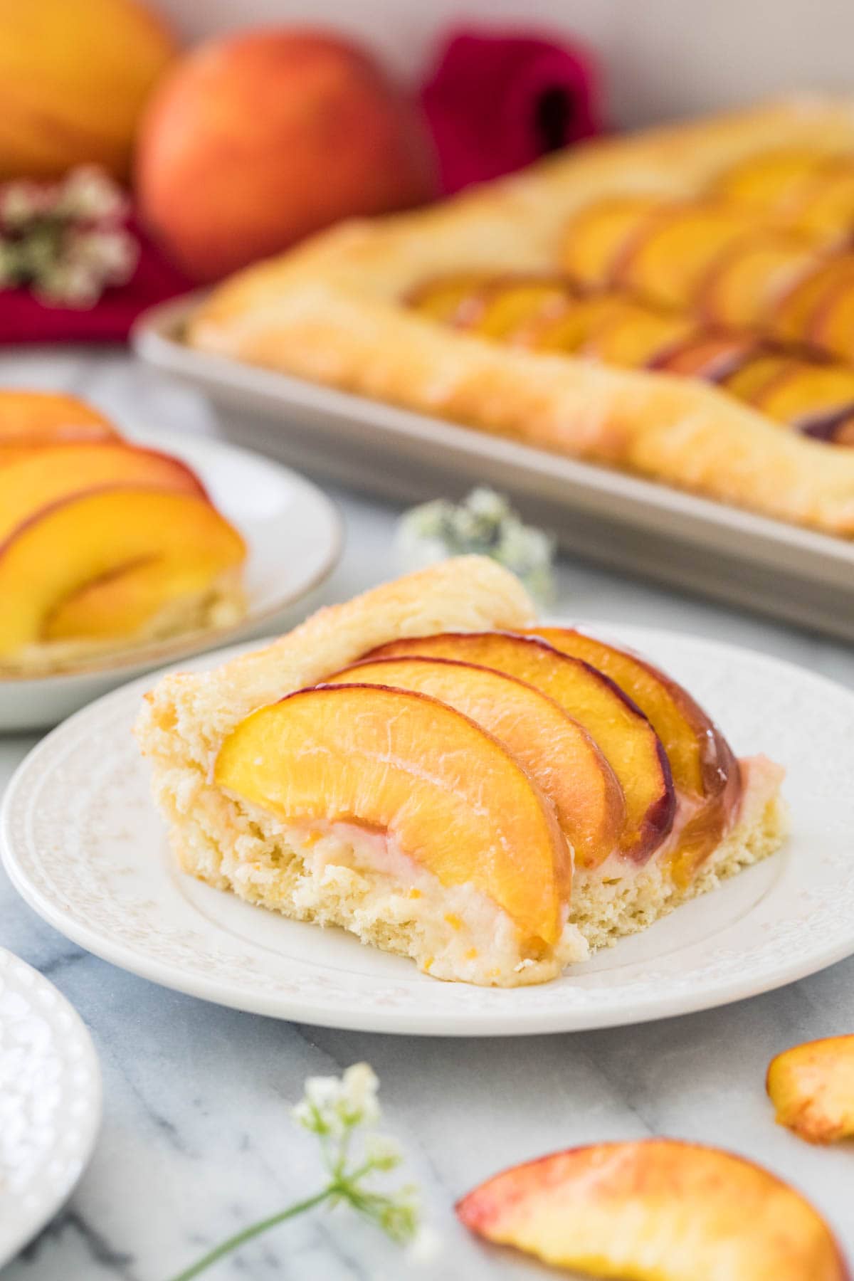 Slice of fresh peach cake on white plate