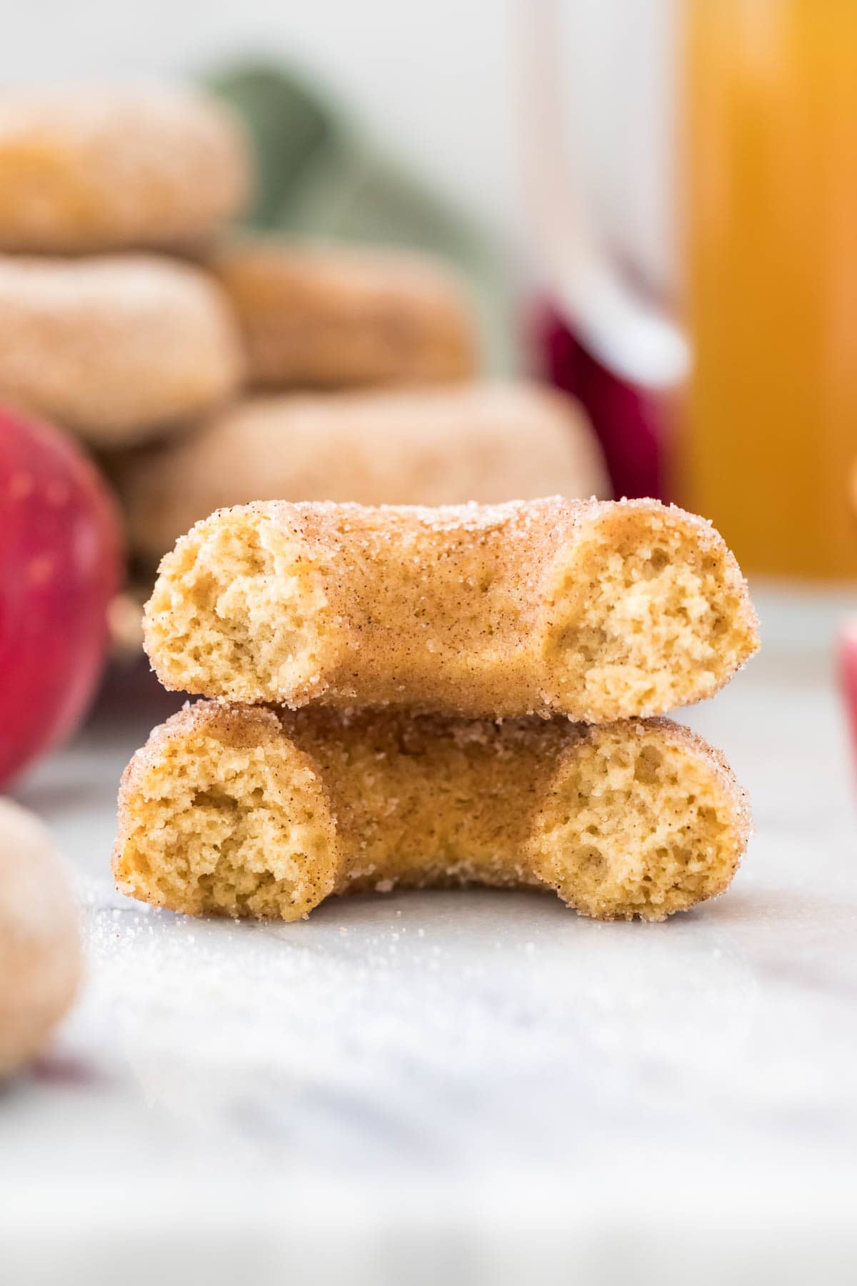 Close-up view of stacked halves of an apple cider donut on white marble
