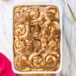 Baking dish full of caramel-glazed apple cinnamon rolls