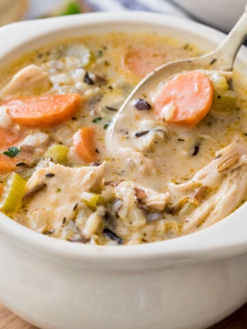 bowl of chicken and rice soup with spoon scooping a bite
