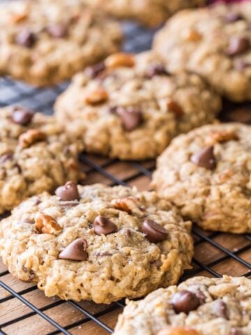 rows of cowboy cookies studded with chocolate chips, coconut, and pecan on black metal cooling rack