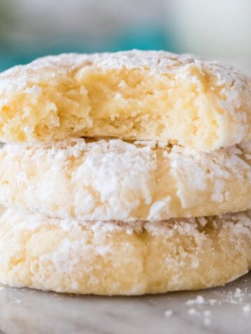 close-up view of three gooey butter cookies stacked on top of each other, with the top cookie missing a bite