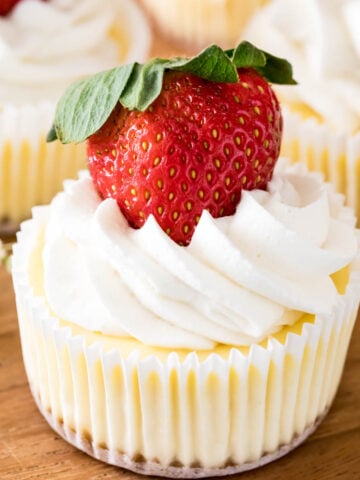 mini cheesecakes topped with whipped cream and a fresh strawberry