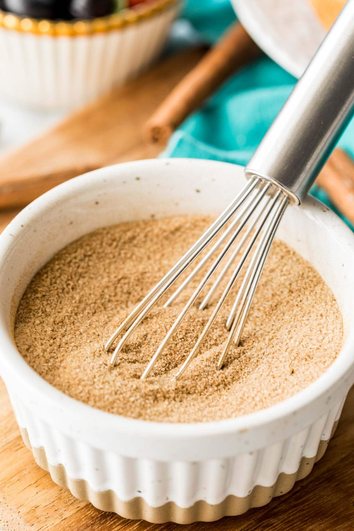 whisk stirring together cinnamon and sugar in a white ramekin