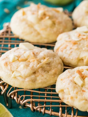 Island cookies topped with coconut and white chocolate chunks resting on a metal cooling rack