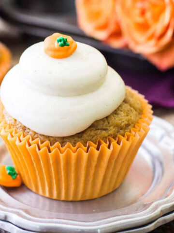 pumpkin cupcake topped with a brown sugar cream cheese frosting and a pumpkin candy