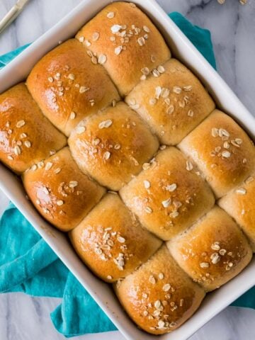 Overhead view of a pan of golden brown honey wheat rolls.