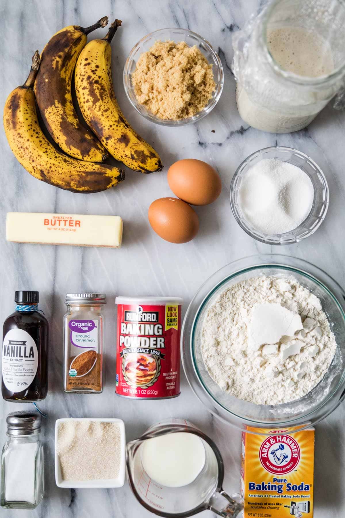 Overhead view of ingredients including ripe bananas, sourdough discard, brown sugar, cinnamon, and more.