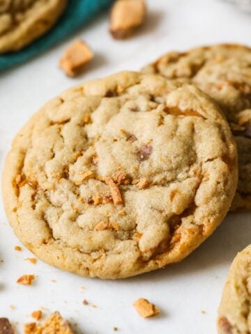 Two butterfinger cookies surrounded by crushed up butterfinger pieces.