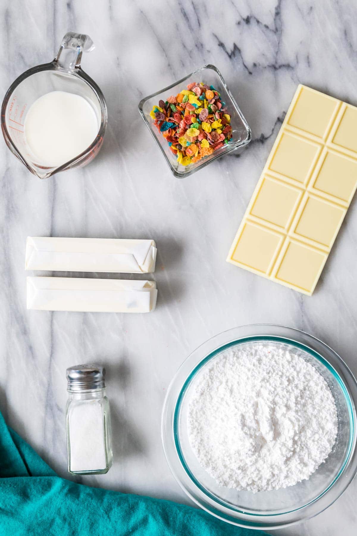 Overhead view of ingredients including white chocolate, fruity pebbles cereal, butter, and more.