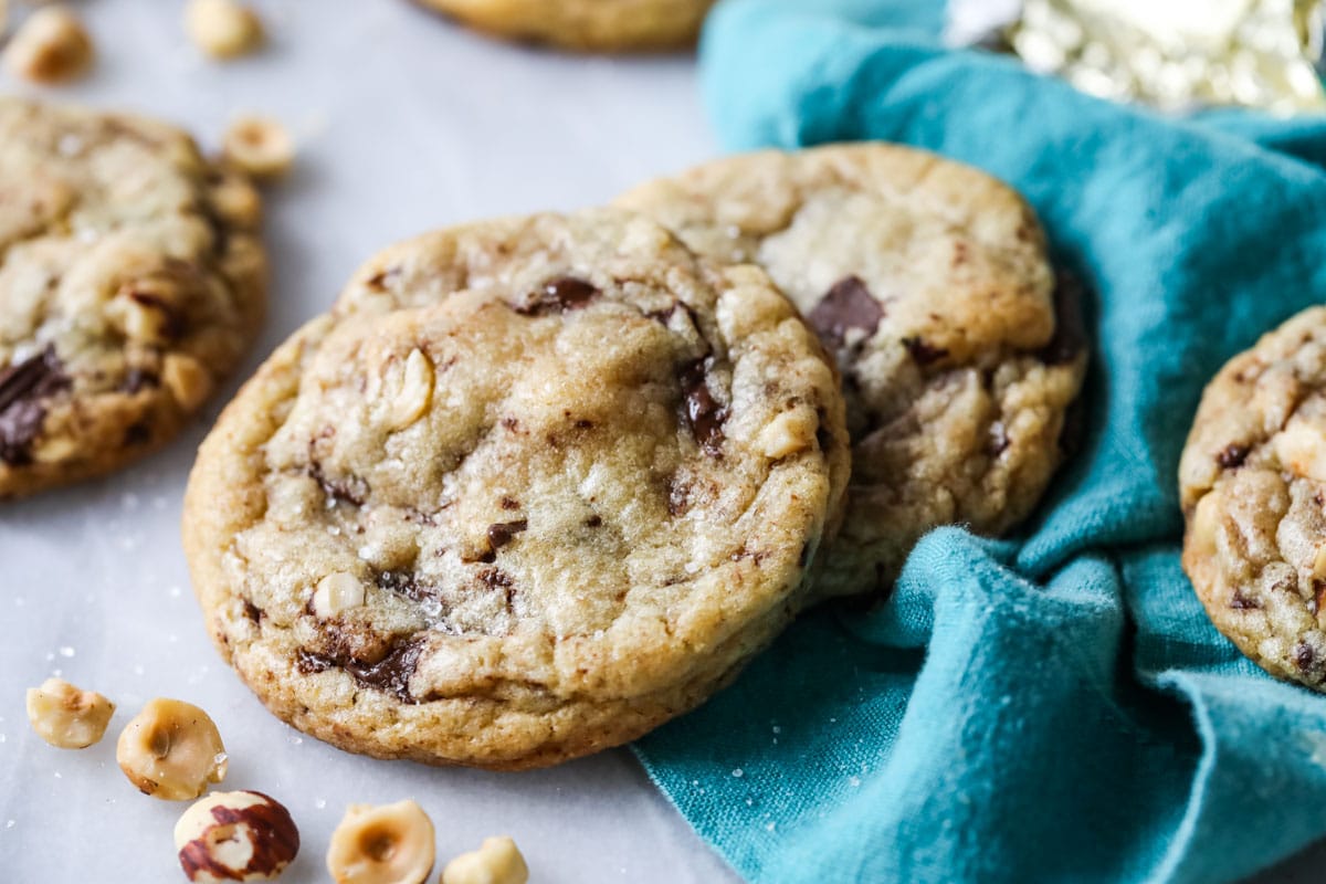 two hazelnut cookies on blue linen