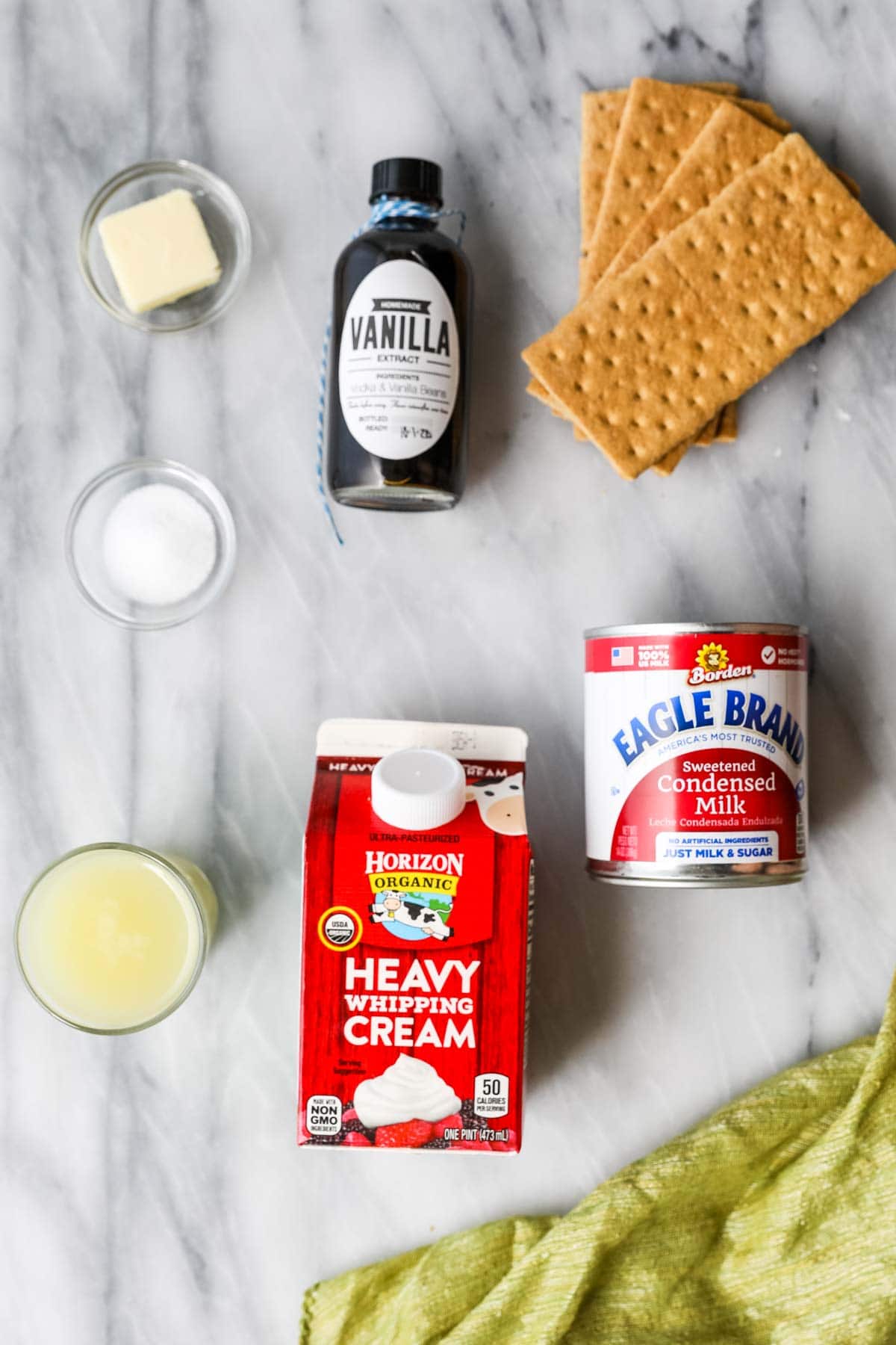Overhead view of ingredients including graham crackers, condensed milk, heavy cream, and more.