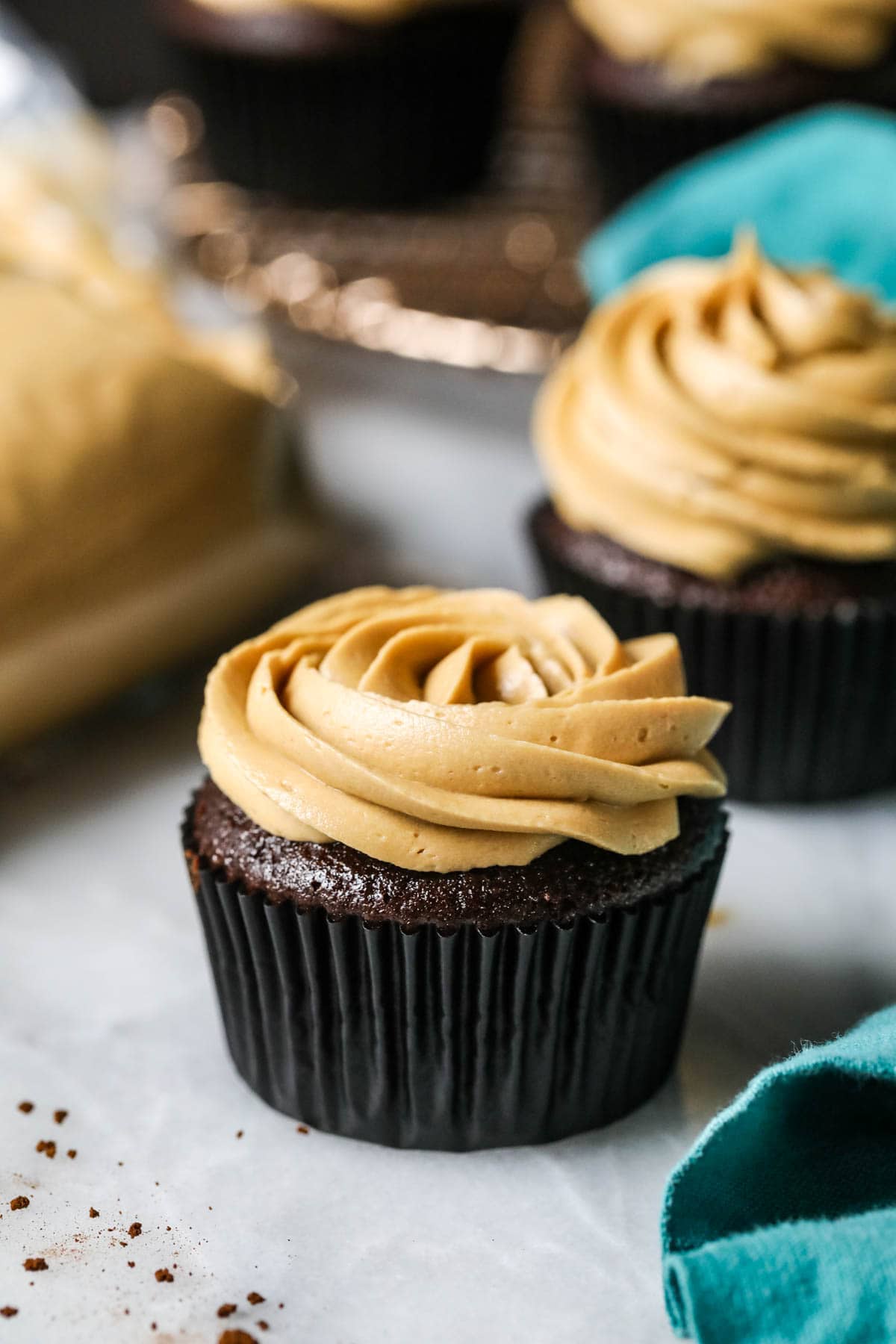 Two cupcakes piped with frosting rosettes made from coffee flavored frosting.