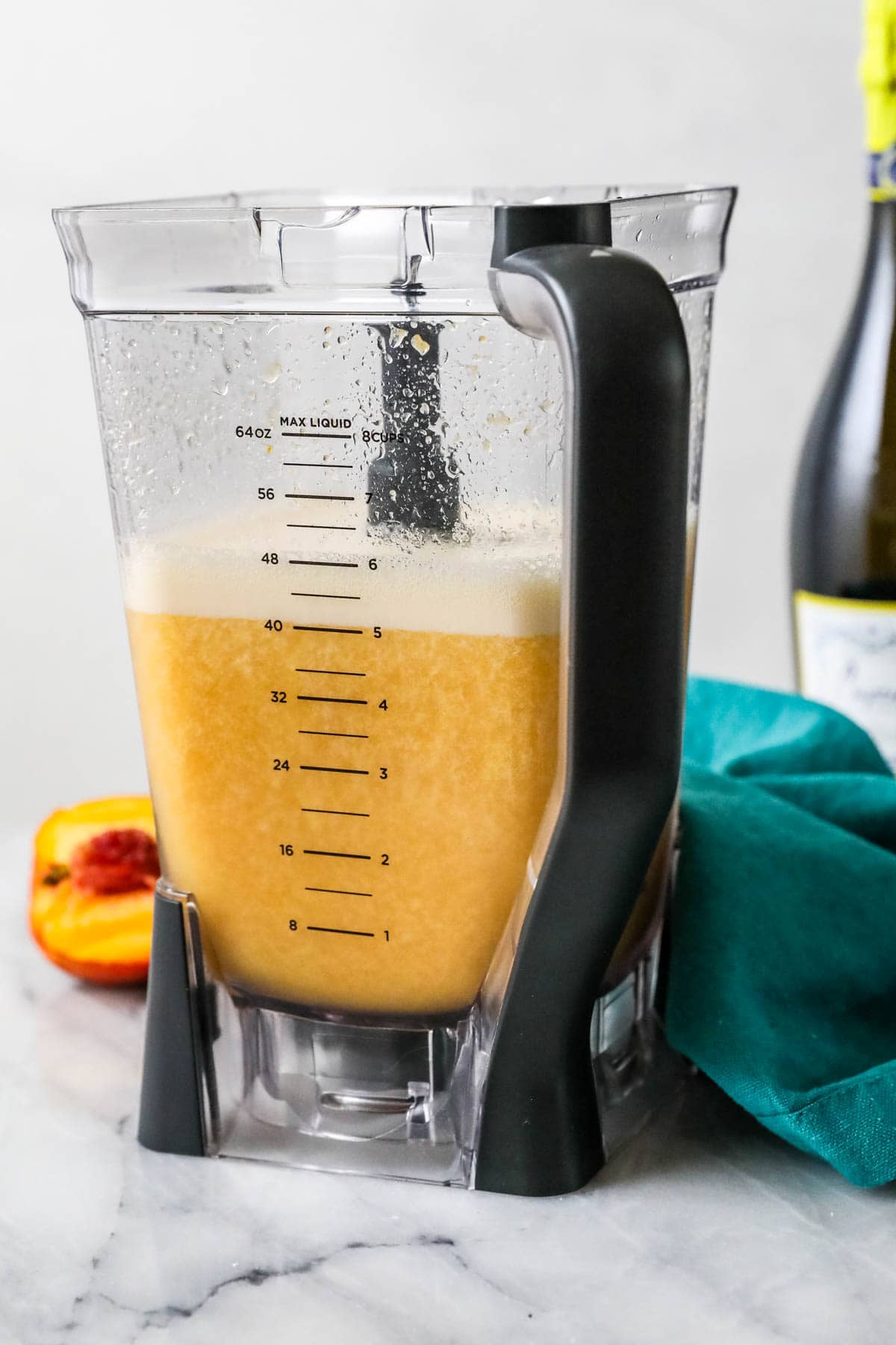 Blender with a blended peach drink inside.