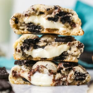Three Oreo cheesecake cookies cut in half and stacked on top of each other.