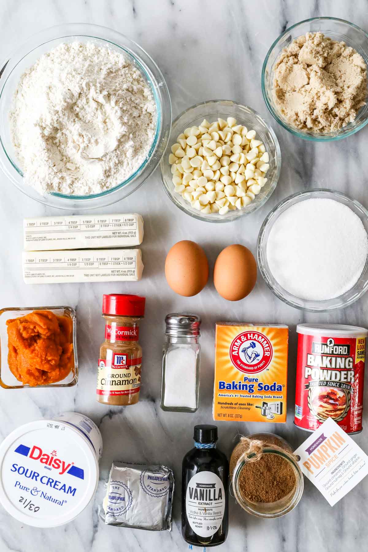 Overhead view of ingredients including pumpkin, cream cheese, white chocolate chips, and more.