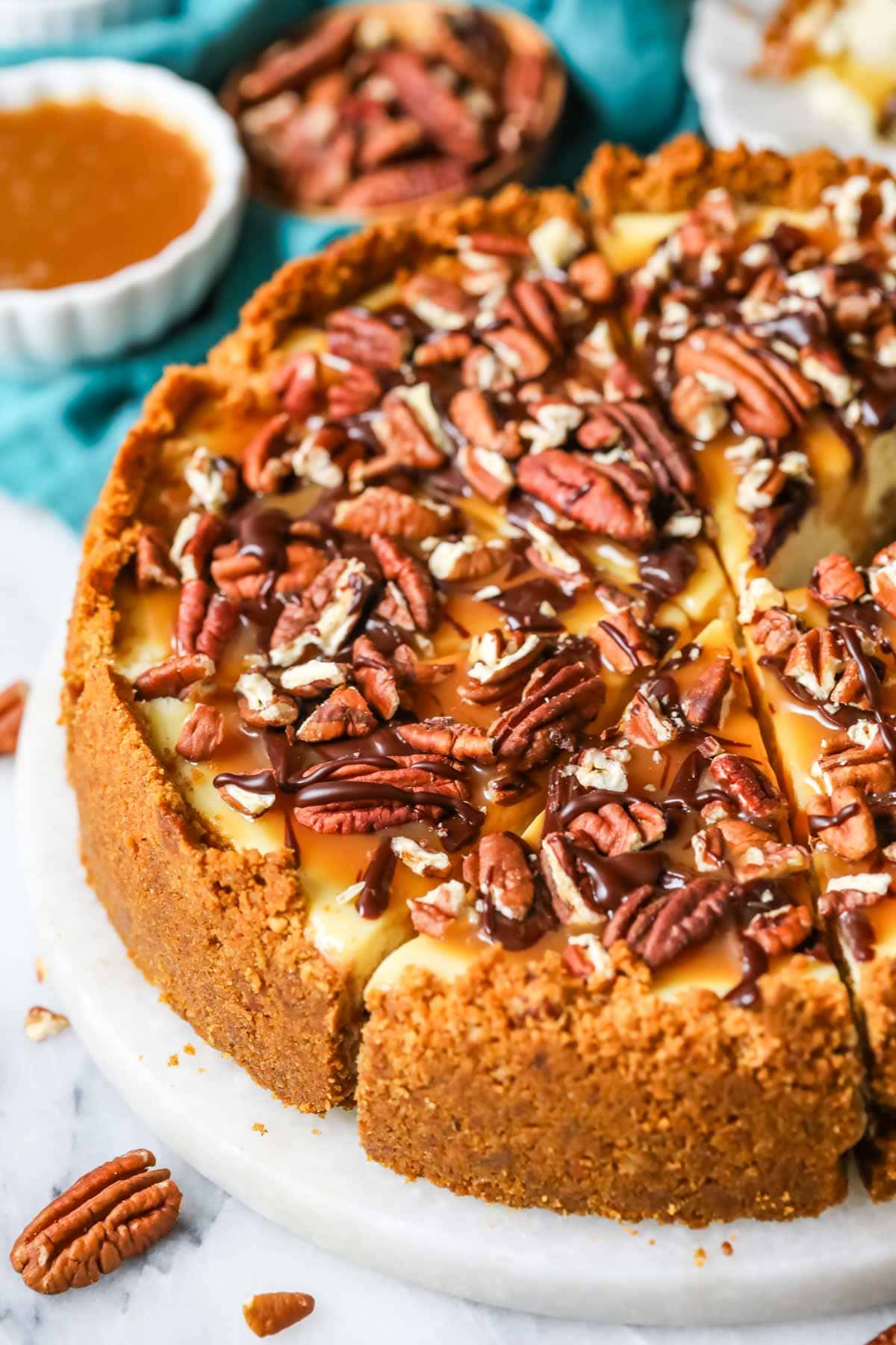 Turtle cheesecake with one slice cut but not removed.
