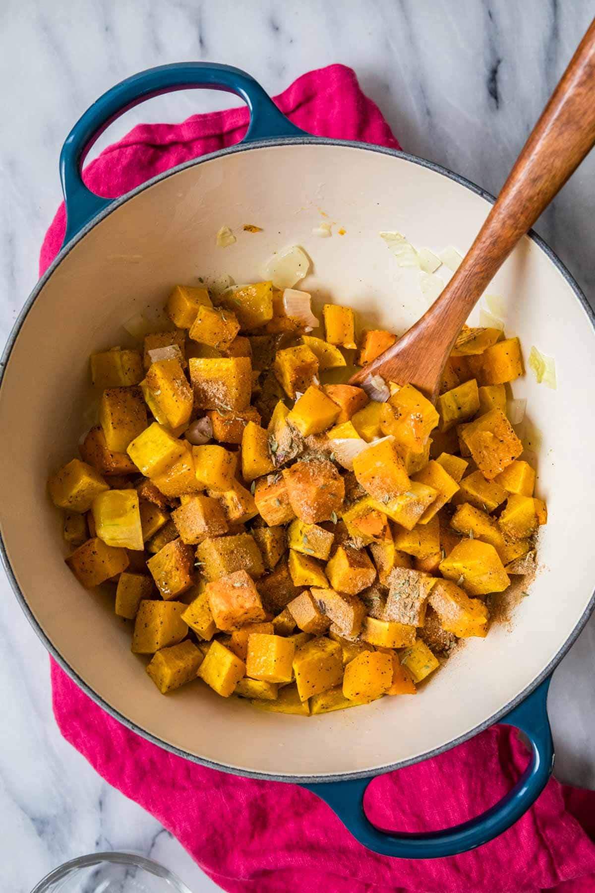 Overhead view of roasted butternut squash and sweet potatoes in a dutch oven.