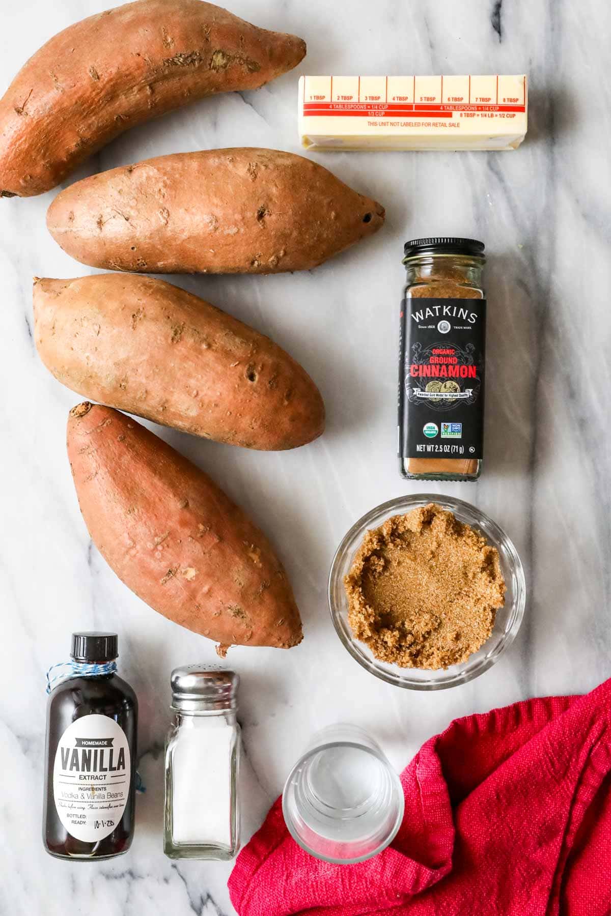 Overhead view of ingredients including sweet potatoes, butter, brown sugar, cinnamon, and more.