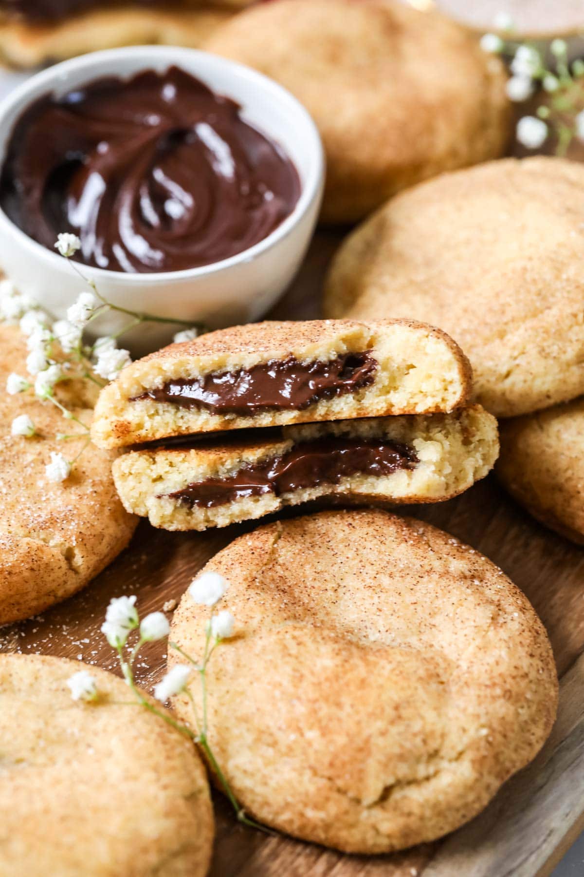 Two halves of a chocolate filled churro cookie among other cookies.