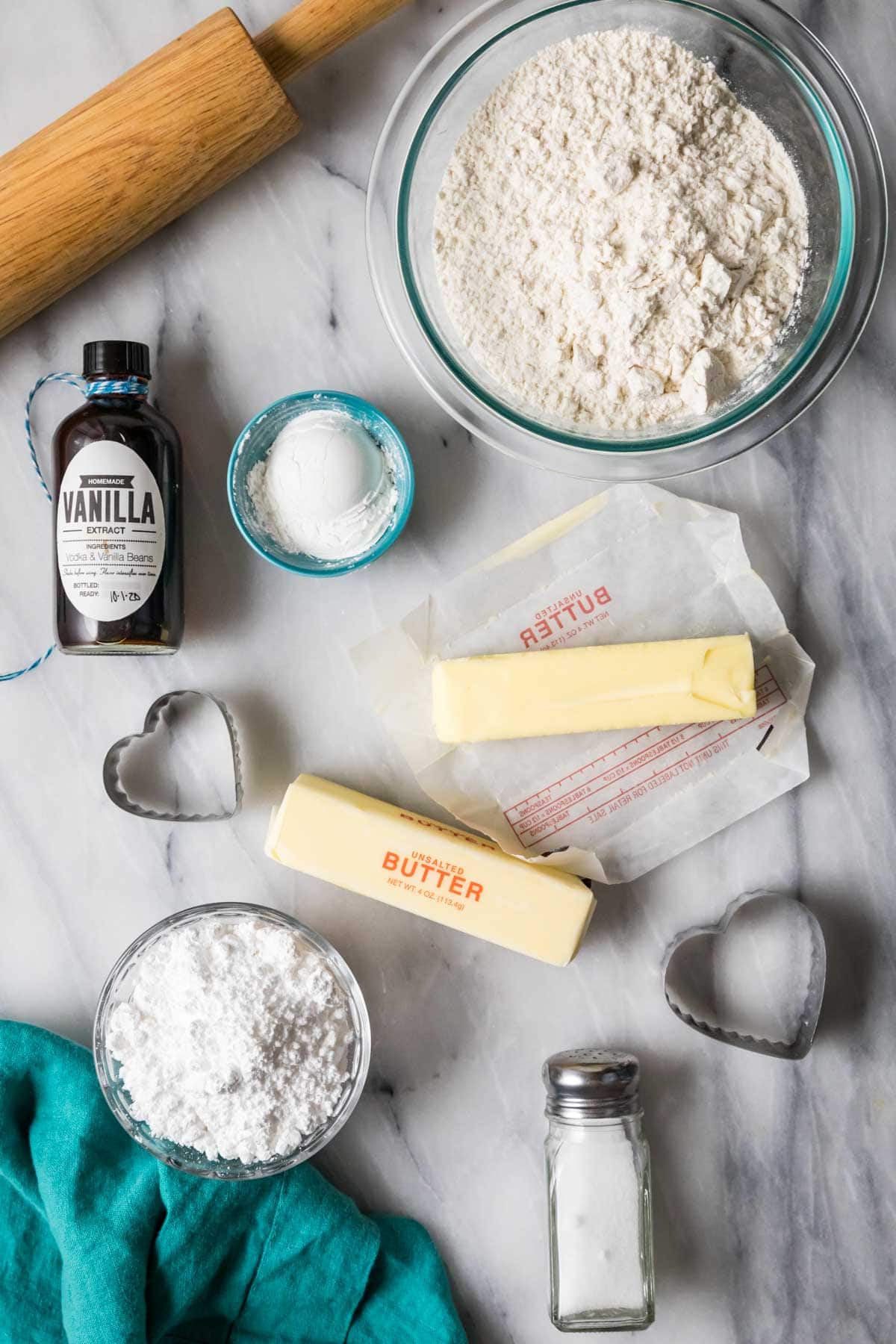 Overhead view of ingredients including butter, flour, powdered sugar, and more.