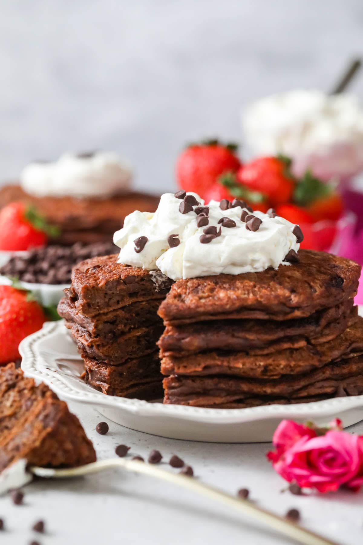 Stack of pancakes made with cocoa powder and chocolate chips with one cut section removed.