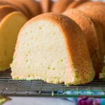 Slice of cream cheese pound cake with the remaining cake behind it.