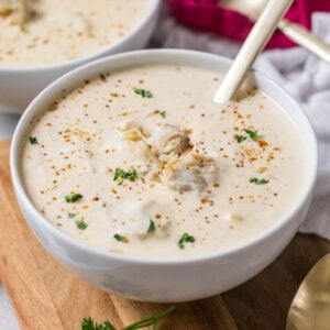 Bowl of cream of crab soup topped with old bay, parsley, and crab meat.