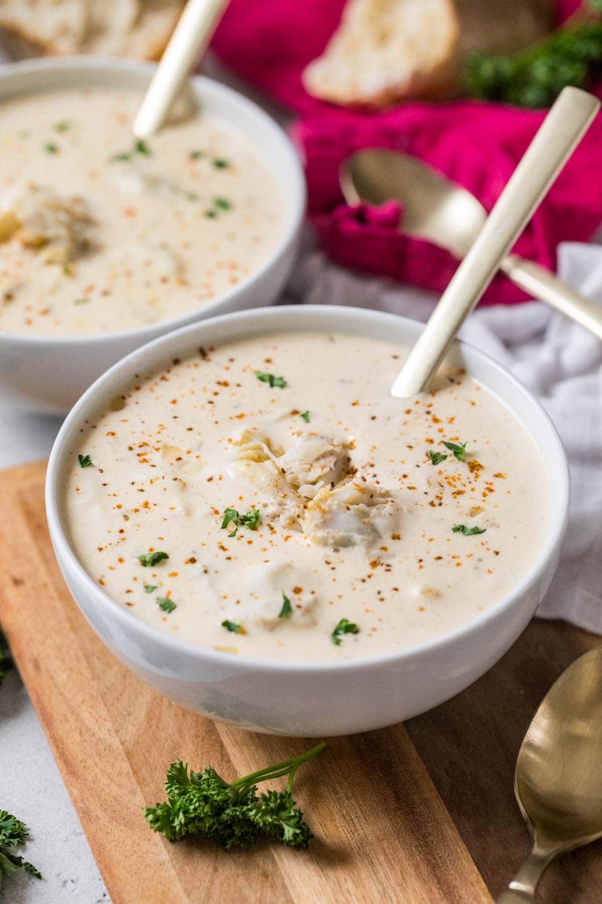 Bowl of cream of crab soup topped with old bay, parsley, and crab meat.
