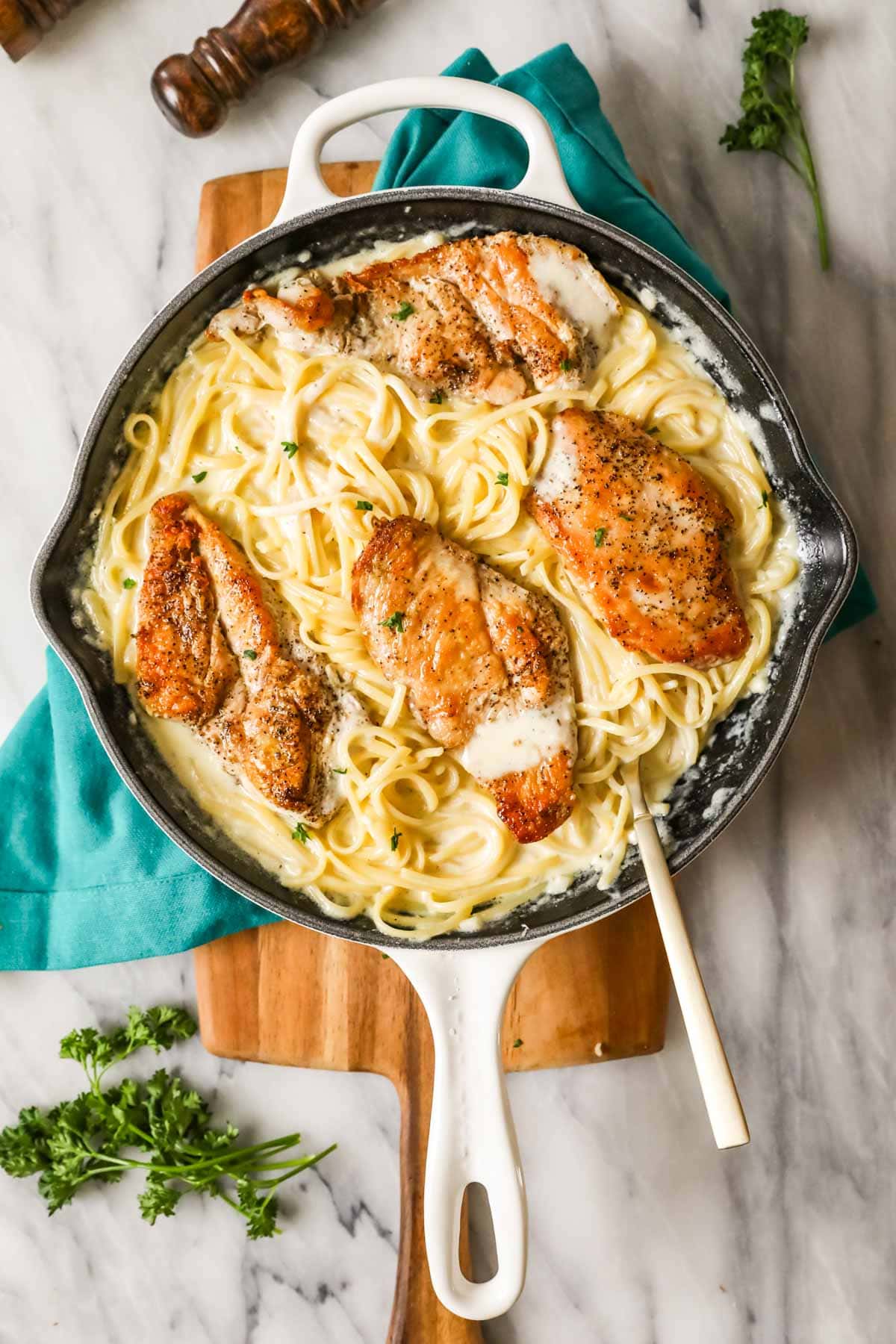 Overhead view of a skillet of chicken alfredo.