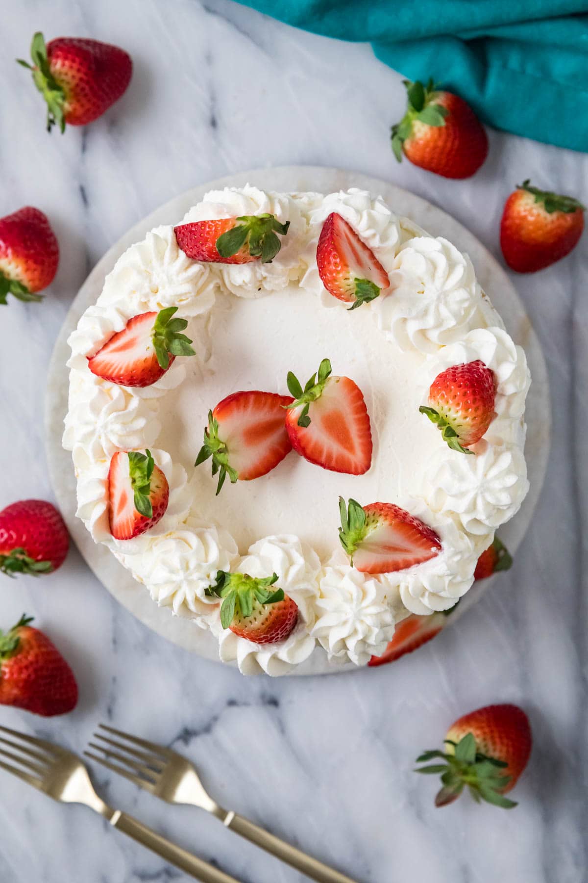 Overhead view of a cake topped with fresh strawberries.