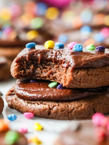 Two cosmic cookies stacked on top of each other with the top cookie missing a bite.