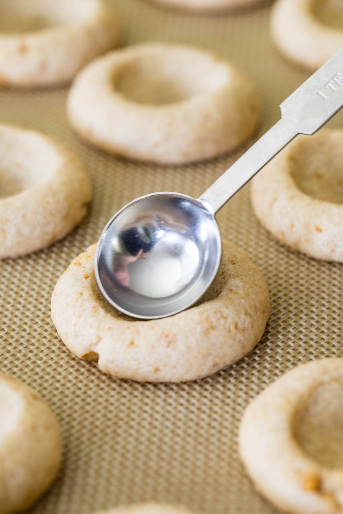 Teaspoon making an indent in cookies after baking.