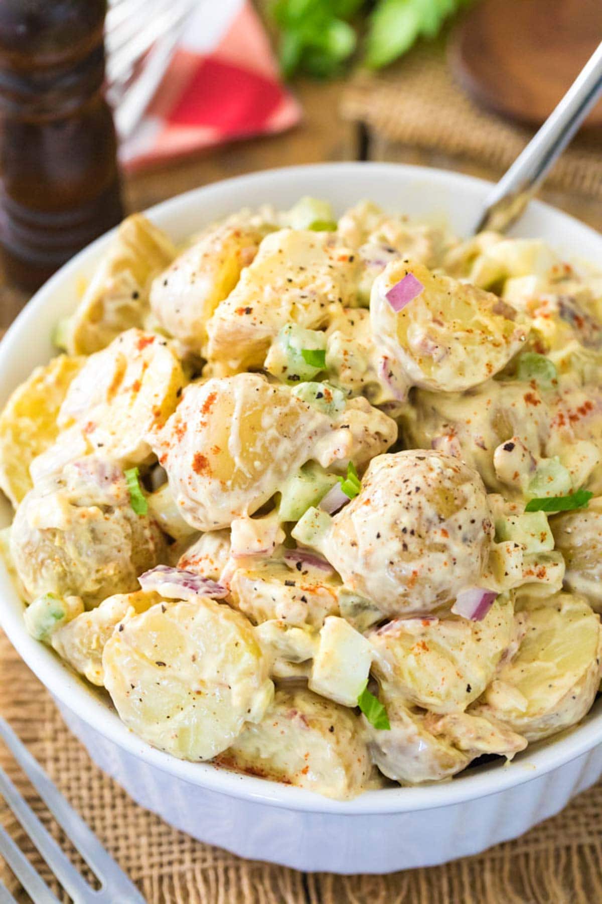 Close-up view of a salad made with potatoes, celery, onions, and more.
