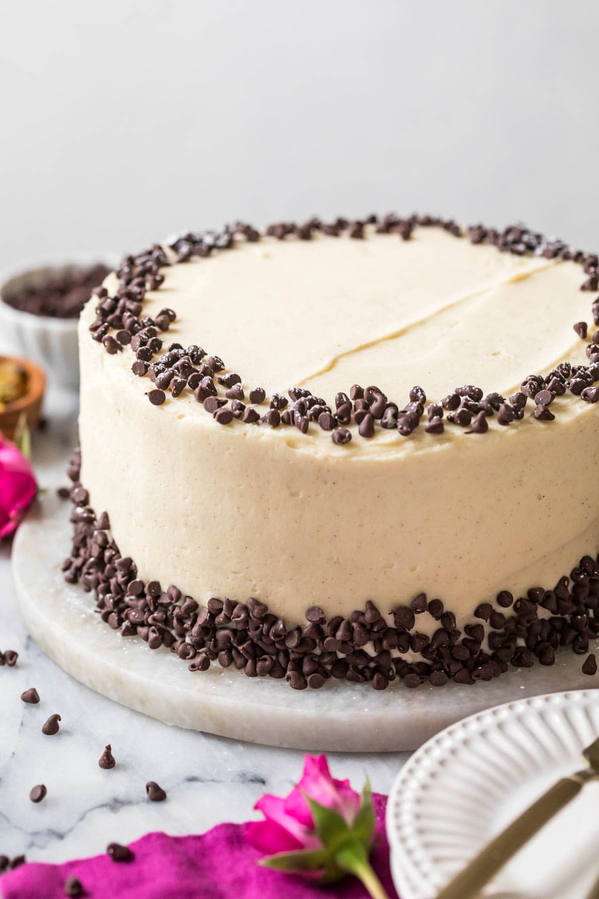 Cake that's been frosted with a mascarpone and ricotta frosting and studded with mini chocolate chips to resemble a cannoli.